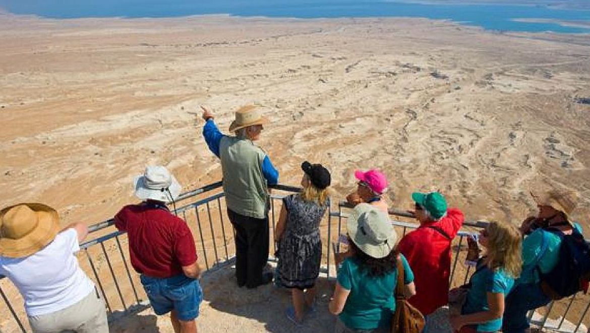 תיירים עם מורה דרך. מארגני התיירות אחראים לסיורי קבוצות של תיירים בישראל. . צילום Depositphotos זכתה במכרז: אמריקן אקספרס גלובל ביזנס טרוול ישראל