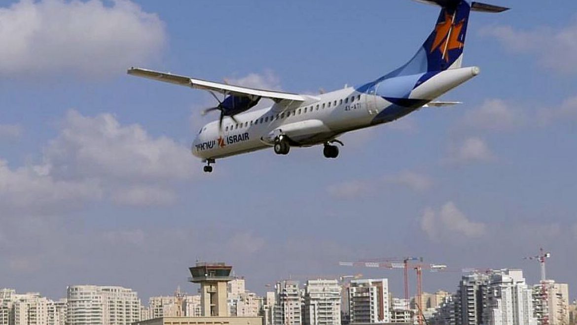 מטוס ישראייר בנחיתה בשדה דב ומבני המגורים הסמוכים אליו מנהלי הגוש הגדול: “הפסקת טיסות ללא פינוי מדיפה ריח חריף של בחירות”