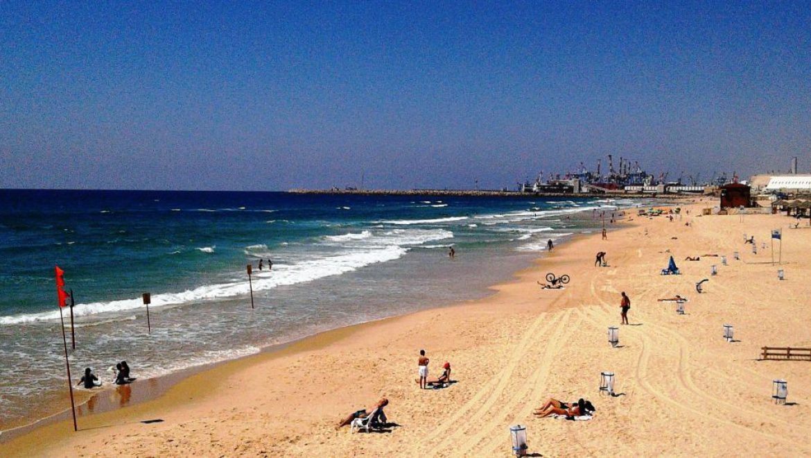 תצפית מסוכת המציל בחוף רחצה אורנים, על חוף לידו ונמל אשדוד. צילום שוש להב העיר אשדוד עולה מבין הגלים